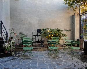 a patio with green chairs and tables and plants at Old Tbilisi in Itʼkhvisi