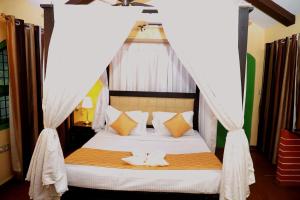 a bedroom with a canopy bed with a cat on it at Ananya Eco Resort in Surūrnagar
