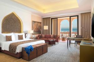 a hotel room with a bed and a living room at Marsa Malaz Kempinski, The Pearl in Doha +129 photos