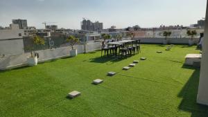 a balcony with a table and chairs on the grass at Hotel Rove Inn in Indore