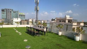 a patio with a table and chairs on a roof at Hotel Rove Inn in Indore