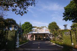 a house with a gate in front of a driveway at Nhat Quang Hotel in Bảo Lộc