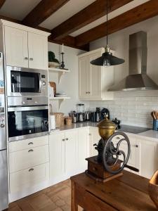 a kitchen with white cabinets and a stove top oven at Casa del Maestro, Seguencu in Següenco