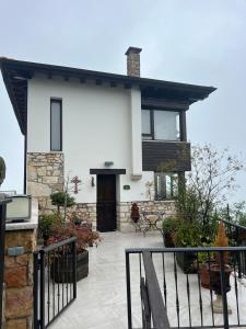 a white house with a porch and a fence at Casa del Maestro, Seguencu in Següenco