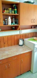 a kitchen with wooden cabinets and a counter top at Erdei weekend ház in Jögödfürdő +4 photos