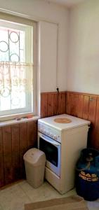 a small kitchen with a stove and a window at Erdei weekend ház in Jögödfürdő