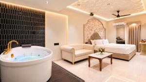 a living room with a bath tub and a bedroom at Hotel Nova Bloom in Ahmedabad
