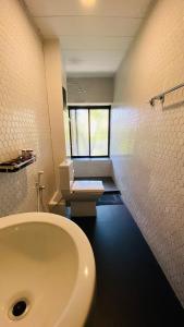 a bathroom with a white sink and a toilet at BBQ HUB Ella in Ella +54 photos