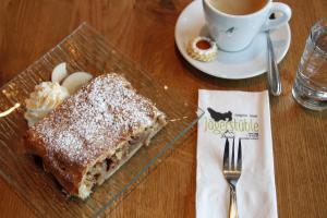a glass plate with a piece of cake and a cup of coffee at Jägerstüble in Damuls