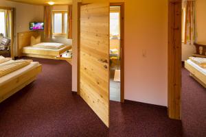 a room with two beds and a wooden wall at Jägerstüble in Damuls