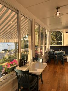 a conservatory with a table and chairs and windows at North Hero House Inn and Resort in North Hero