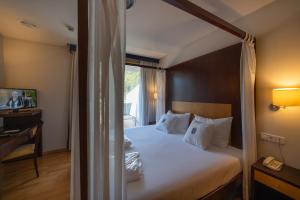 a hotel room with a bed and a telephone at Lobios Caldaria Hotel Balneario in Bubaces