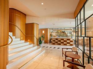 a lobby of a building with stairs and chairs at Mondrian Cannes in Cannes