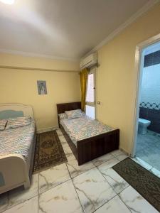 a room with two beds and a bathroom with a window at شالية ديمورا للعائلات in Dawwār Muḩammad Abū Shunaynah +24 photos