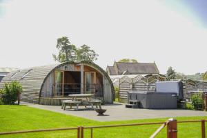 a circular building with a picnic table in a yard at Bluebell in Rhayader