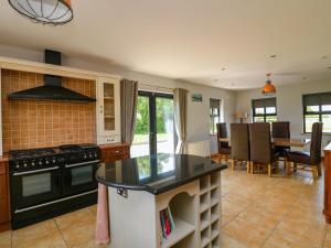 a kitchen with a stove and a dining room at Strand House in Bannow