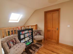 a living room with a couch and a book shelf at Strand House in Bannow