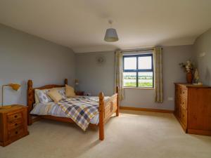 a bedroom with a bed and a window at Strand House in Bannow