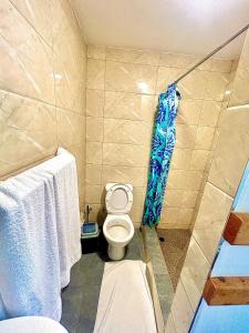 a bathroom with a toilet and a shower with towels at Residencial Nyelete in Vilanculos