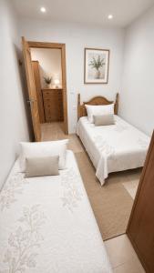 a bedroom with two beds and a mirror at Poseidón in Quesada