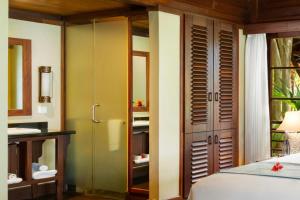 a bedroom with green walls and a bed and a closet at Enchanted Island Resort in Mahe