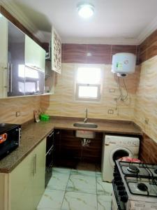 a small kitchen with a stove and a sink at شالية ديمورا للعائلات in Dawwār Muḩammad Abū Shunaynah
