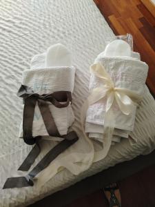 zwei Handtücher mit Schleife auf einem Bett in der Unterkunft Casa Malignani in Lunghezza