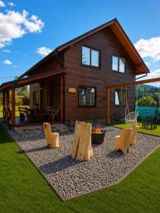 a log cabin with chairs and a house at Гостинний двір in Vorokhta +19 photos