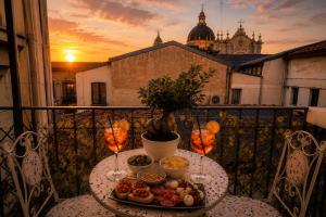 a table with a plate of food on a balcony at Duomo View Apartment in Catania
