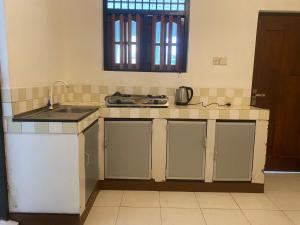 a kitchen with a sink and a counter top at Courtyard Hostel Negombo in Negombo