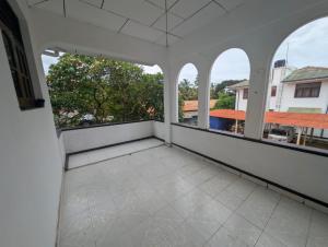 a large balcony with windows and white walls at Courtyard Hostel Negombo in Negombo