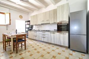 a kitchen with wooden cabinets and a table with a tableablish at S'Archittu Sea Retreat in S'archittu Cuglieri