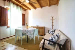 a living room with a table and chairs and a couch at S'Archittu Sea Retreat in S'archittu Cuglieri