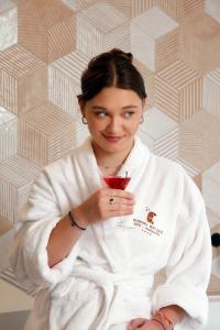 a woman in a robe holding a drink at Hotel Boutique Mediodía & Apartments in Plan