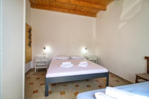 a bedroom with a bed with two towels on it at S'Archittu Sea Retreat in S'archittu Cuglieri