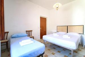 a bedroom with two beds and a light fixture at S'Archittu Sea Retreat in S'archittu Cuglieri +7 photos