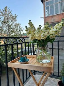 a wooden table with a vase of flowers on a balcony at Studio Apartment Goris in Goris +6 photos