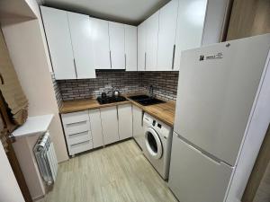 a small kitchen with a white refrigerator and a washer at Studio Apartment Goris in Goris