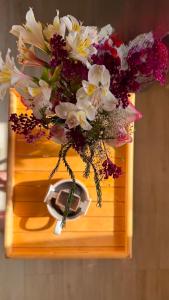 a vase filled with flowers on a wooden tray at Studio Apartment Goris in Goris