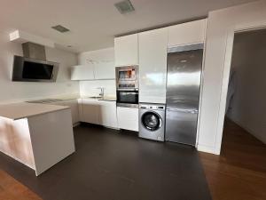 a kitchen with a stainless steel refrigerator and a dishwasher at Samsara in San Sebastián +15 photos