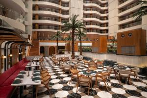 a restaurant with tables and chairs and tall buildings at Welcomhotel by ITC Hotels, Dwarka, New Delhi in New Delhi