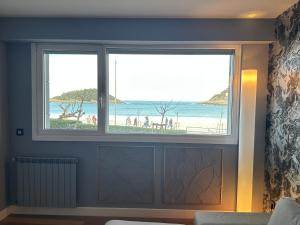 a room with two windows with a view of a beach at Samsara in San Sebastián