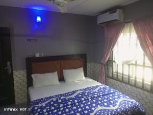 a bedroom with a bed with a blue light at Pleasure rest hotel and suites in Uyo