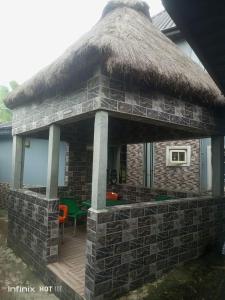 a house with a thatched roof and a deck at Pleasure rest hotel and suites in Uyo