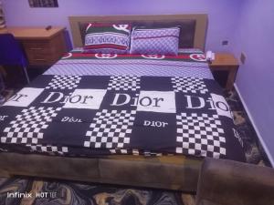 a bed with a checkered blanket on top of it at Pleasure rest hotel and suites in Uyo