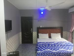 a bedroom with a bed and a tv in it at Pleasure rest hotel and suites in Uyo