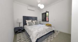 a white bedroom with a large bed in it at Solstice Villa Private Pool & BBQ Cascais in Alcabideche