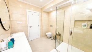 a bathroom with a glass shower and a toilet at Solstice Villa Private Pool & BBQ Cascais in Alcabideche