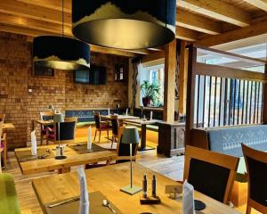 a restaurant with tables and chairs and a brick wall at Pension Bergheim in Tannheim