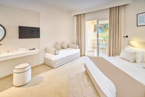 a white hotel room with a bed and a couch at Houda Yasmine Marina & SPA in Hammamet